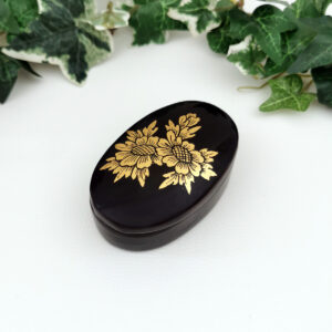 Petite boîte ovale laquée noire à motif doré floral, typique des souvenirs asiatiques des années 60 à 80