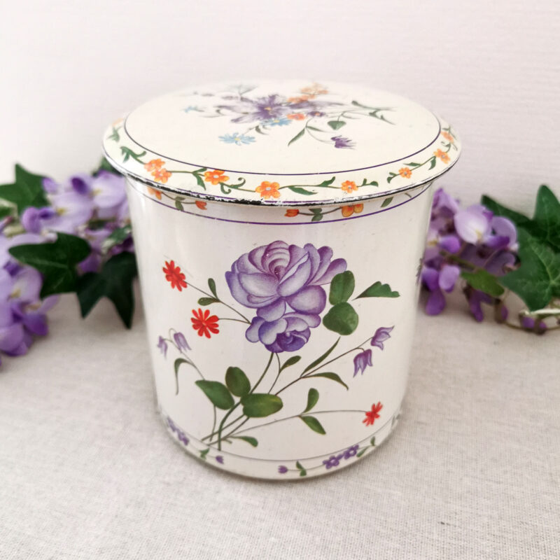 boîte en métal vintage décorée de fleurs violettes sur fond crème