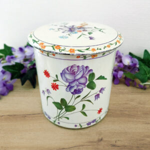 boîte en métal vintage décorée de fleurs violettes sur fond crème