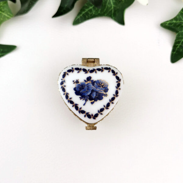 Mini-boîte en porcelaine de Bourgogne en forme de cœur, décorée de fleurs bleues et dorures avec fermoir en métal doré.