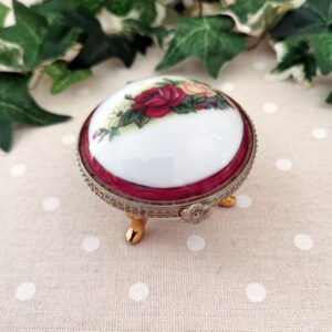 Boîte ronde en porcelaine blanche à pieds dorés, décor floral sur couvercle et fermeture en laiton