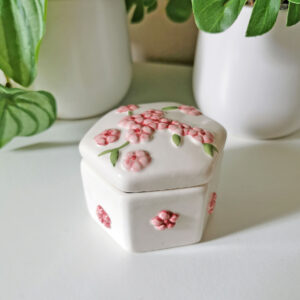 Petite boîte hexagonale blanche en céramique décorée de fleurs roses en relief