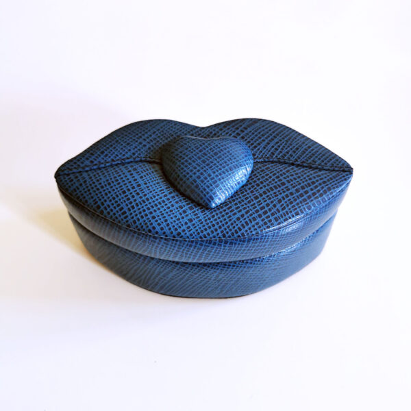 boîte bleue en forme de lèvres avec cœur central en relief, fermée
