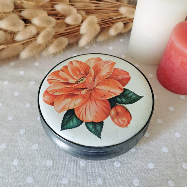 Boîte en métal vintage à fleur orange et fond crème sur le couvercle