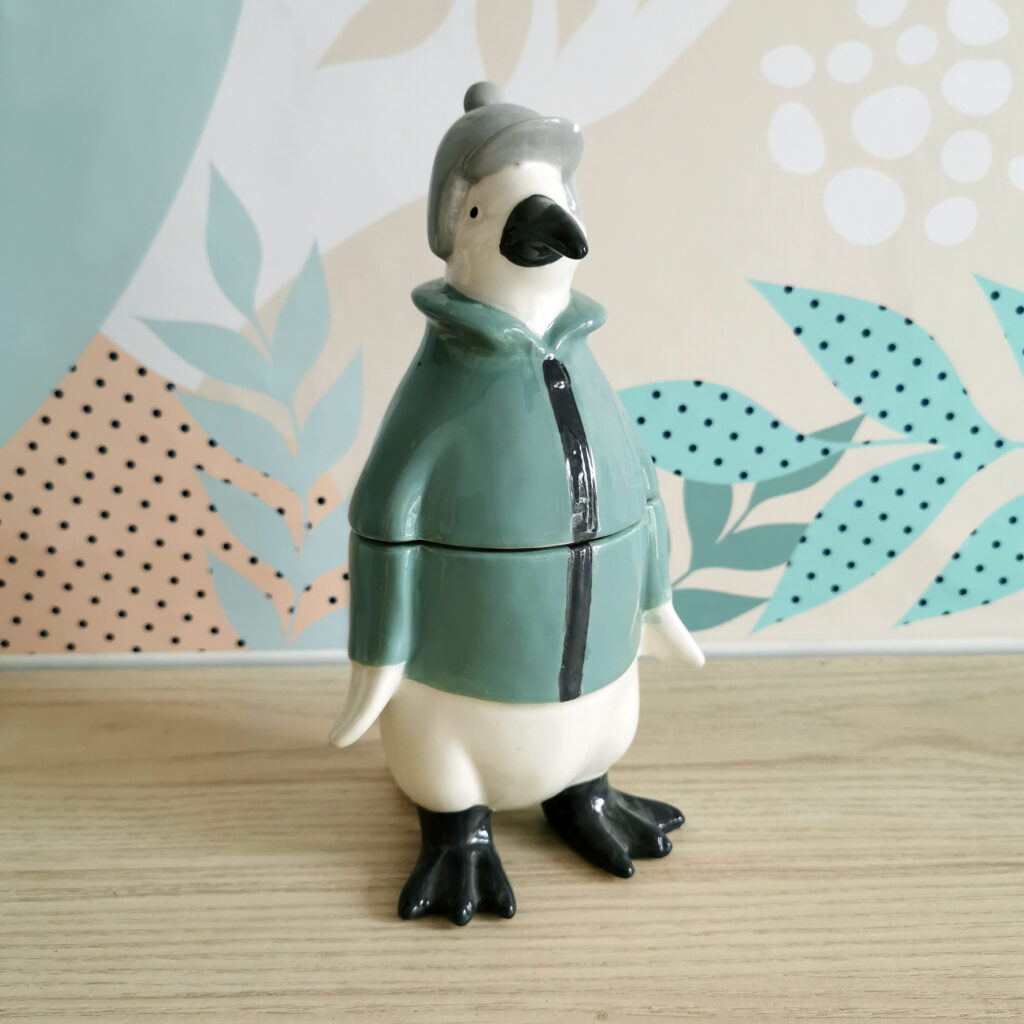 boîte en céramique en forme de pingouin rigolo avec manteau vert et bonnet gris